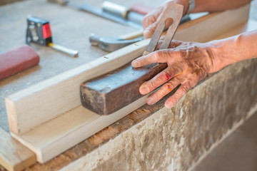 picture The carpenter is working on the wood with tools.