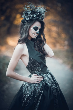 Closeup portrait of Calavera Catrina in black dress. Sugar skull makeup. Dia de los muertos. Day of The Dead. Halloween