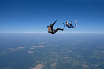 Skydiving. An instructor trains a student to fly.