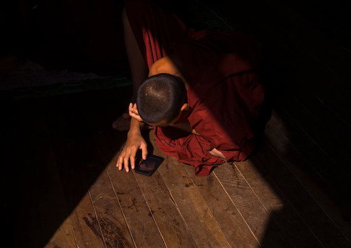Novice Buddhist In Shwe Yan Pyay Monastery Playing With His Mobile Phone, Myanmar