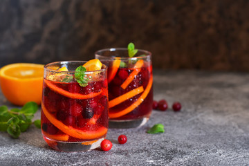 Cold cranberry juice with orange and mint. Summer drink.