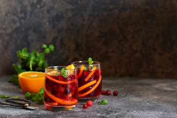 Cold cranberry juice with orange and mint. Summer drink.