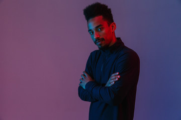 Portrait of handsome african american man in sportswear poising at camera with his arms crossed