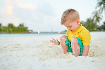 Three year old toddler boy on beach. Summer family vacation at Maldives.