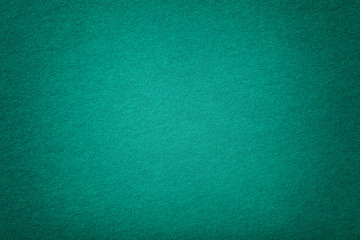 Dark turquoise matt suede fabric closeup. Velvet texture of felt.