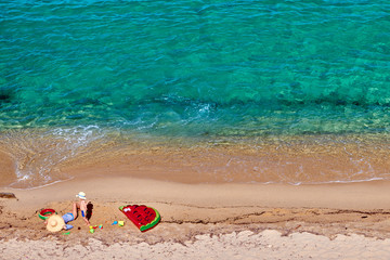 Two year old toddler boy and his mother on beach with inflatable float and ring. Summer family...