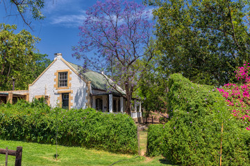 Fototapeta na wymiar Traditional south african countryside house and garden with blooming trees and bushes
