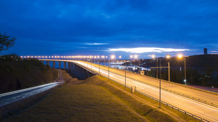 Fototapeta na wymiar Night view of the bridge with traffic lights and cloudy dramatic sky in Vladivostok, Russia