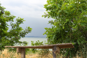 Storm clouds over the sea and the city.Old wooden bench against the background of the sea.