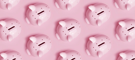Many piggy banks in rows on pink background, top view