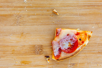 Pizza slice on wood cutting board