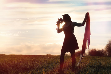 Fototapeta premium A girl in a hat on a walk in the park. A girl with a basket walks in autumn. A girl is walking along the road at sunset.