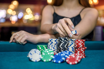 Female hand taking poker chips from pile