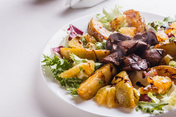 Baked potatoes with boiled chicken liver on a plate