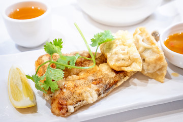 Delicious dim sum, famous cantonese food in asia - Fried fish and dumplings with lemon, sauce and tea in hong kong yumcha restaurant, close up