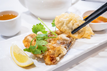 Delicious dim sum, famous cantonese food in asia - Fried fish and dumplings with lemon, sauce and tea in hong kong yumcha restaurant, close up