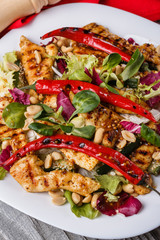 Mexican salad with hot pepper chiken fillet lettuce on plate