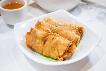 Delicious dim sum, famous cantonese food in asia - Fried bean curd (tofu skin) rolls with shrimp and prawn in hong kong yumcha restaurant, close up