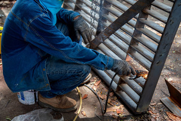 A worker welding metal Drain cap.