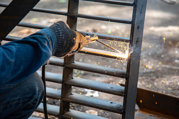 A worker welding metal Drain cap.