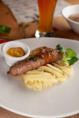 Traditional german sausage with mashed potato served with gravy and mustard