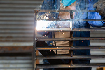 A worker welding metal Drain cap.