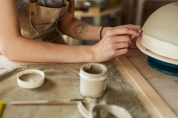 Fototapeta na wymiar High angle closeup of unrecognizable female artisan shaping handmade bowl on potters wheel, copy space