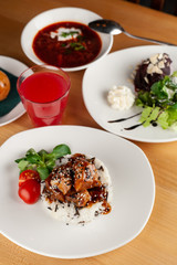 Close up of a three course meal: traditional russian borscht, beef steak with rice and salad