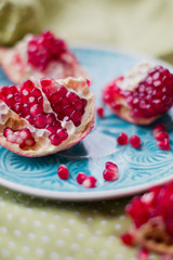 Ripe pomegranate fruit on blue plate
