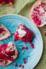 Ripe pomegranate fruit on blue plate