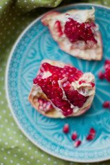 Ripe pomegranate fruit on blue plate