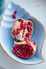 Ripe pomegranate fruit on blue plate