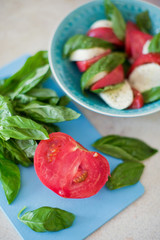 Delicious caprese salad with ripe tomatoes and mozzarella cheese with fresh basil leaves