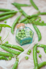 fresh green peas and small glass bottle