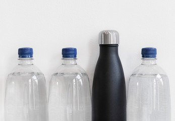 Plastic bottles with reusable bottle made from stainless steel. Plastic free alternative concept, with copy space.