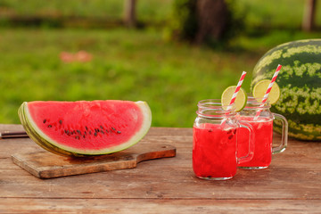Watermelon smoothies with lime and watermelon sliced ripe on wooden table.