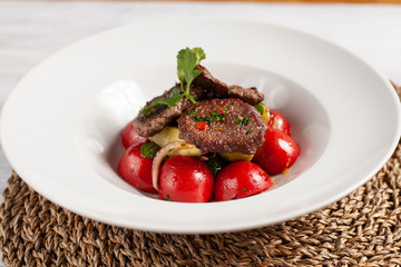 Close up of mini steaks with mashed potatoes and onion, served on white plate