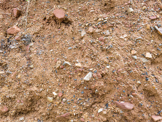 Close-up Red ground and small stones background Some plants can be cultivated.