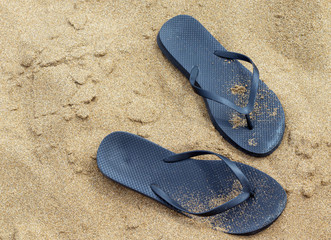 Flip flop sandals on a sandy beach. Summer concept with copy space.