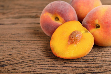 Fototapeta na wymiar whole and half cut ripe peach on wooden background