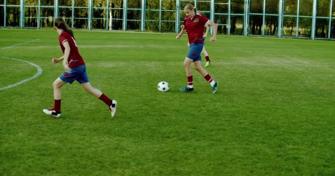 TRACKING Caucasian teenager girl soccer football team scoring a goal against opposing team. 4K UHD 60 FPS SLOW MOTION