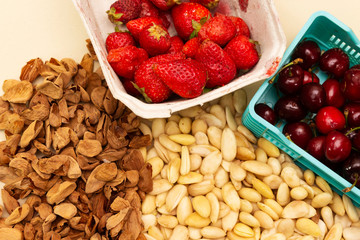 raw peeled almonds and strawberry box and cherry on basket