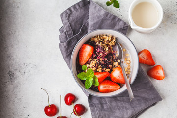 Baked oatmeal with berries and milk in a gray bowl, top view. Vegan breakfast.