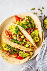Vegan tortillas with quinoa, asparagus, beans, vegetables and guacamole.
