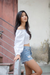 Portrait of thai adult beautiful girl White shirt blue jeans relax and smile