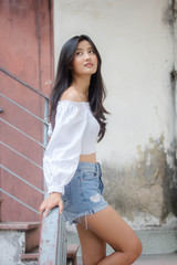 Portrait of thai adult beautiful girl White shirt blue jeans relax and smile