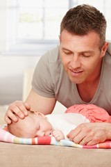 Obraz na płótnie Canvas Father carefully touching sleeping baby