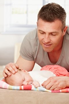 Father carefully touching sleeping baby