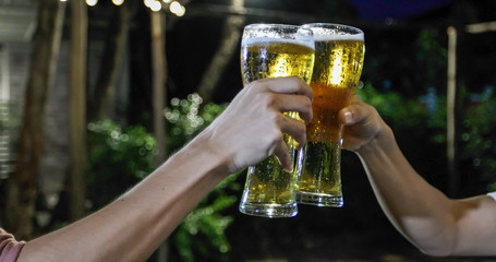 Asian group of friends having party with alcoholic beer drinks and Young people enjoying at a bar toasting cocktails and clinking glasses