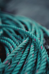 Detail shot of a colorful turquoise blue sailing rope found on a fishing boat in a harbor. Port Andratx, mallorca Spain
